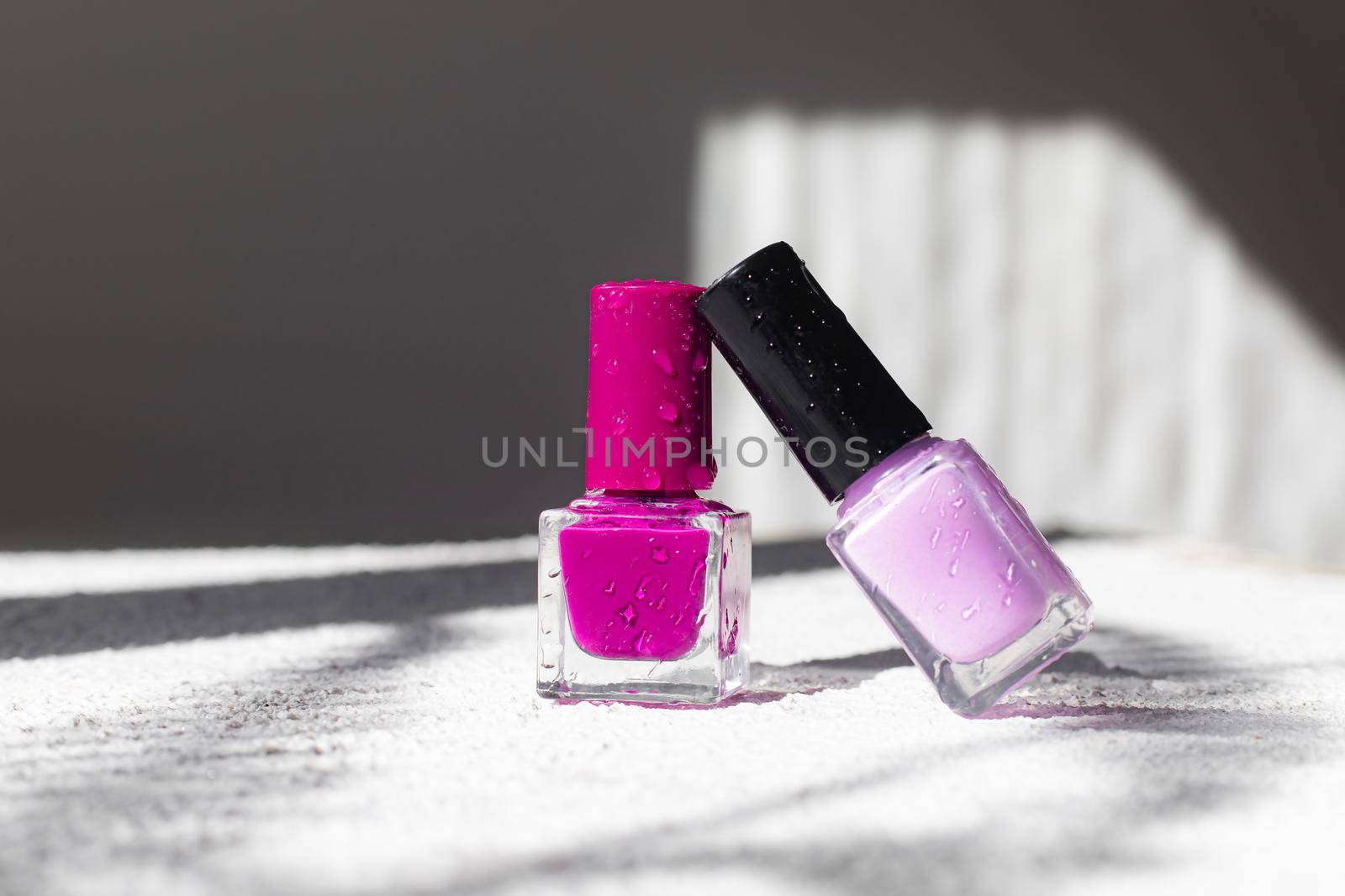 Nail polish on a white background with shadows . The concept of nail polish without inscriptions. Light background and shadows. Copy space . Article about the choice of varnish. Cosmetology