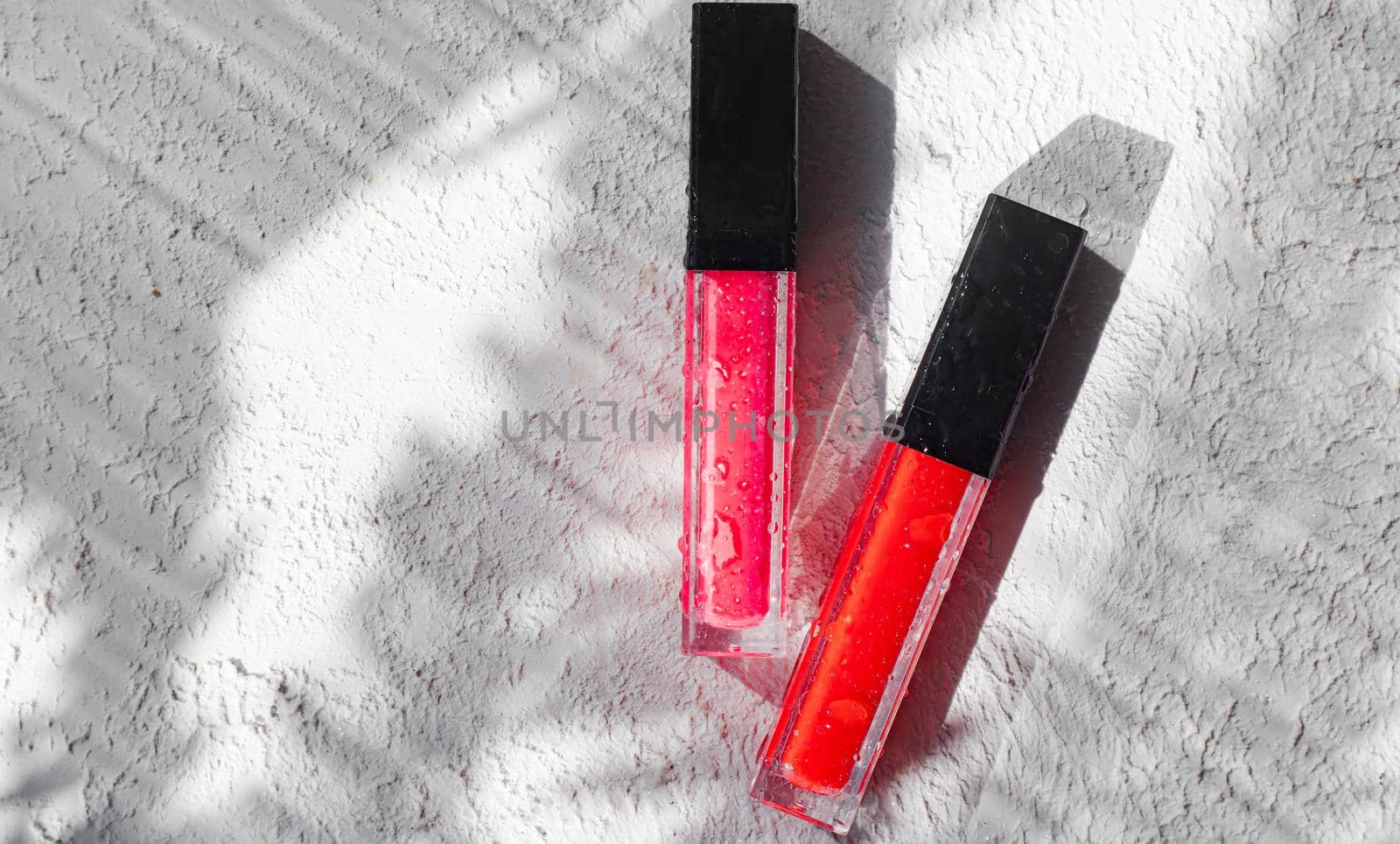 Lip gloss and sun shadow . The concept of lip gloss without labels. Decorative cosmetics. Lip care. Copy space