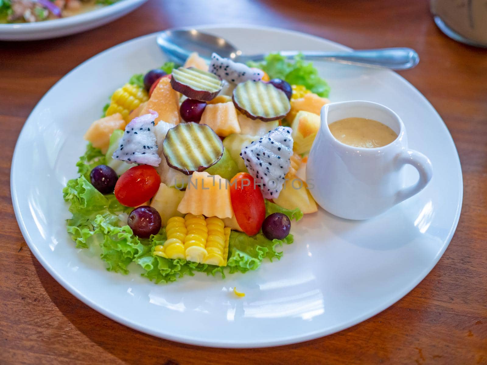 Vegetable salad on a white plate placed on a wooden background. by Unimages2527