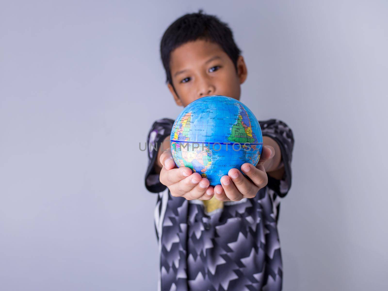 boy holding a globe stand out in front Show the power of the new generation to continue to develop our world. by Unimages2527
