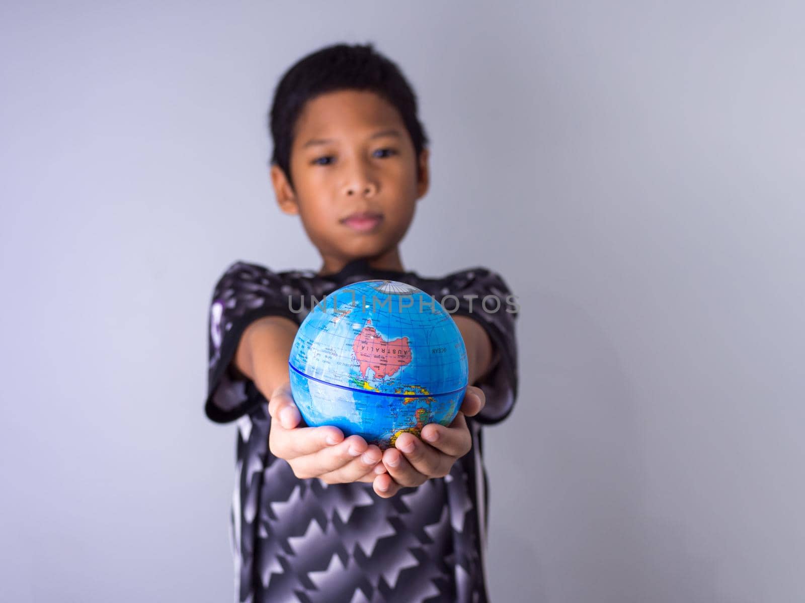 boy holding a globe stand out in front Show the power of the new generation to continue to develop our world. by Unimages2527
