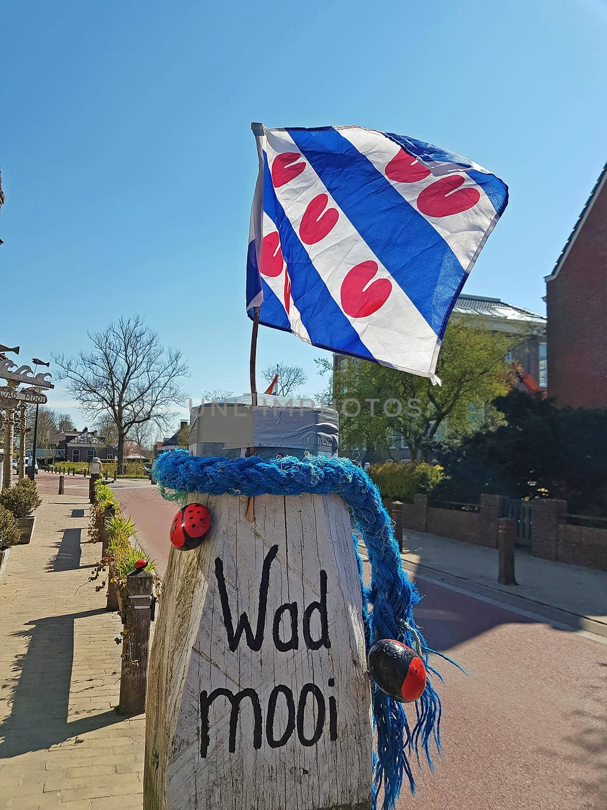 The frisian flag on a pole with the words 'Wad Mooi'