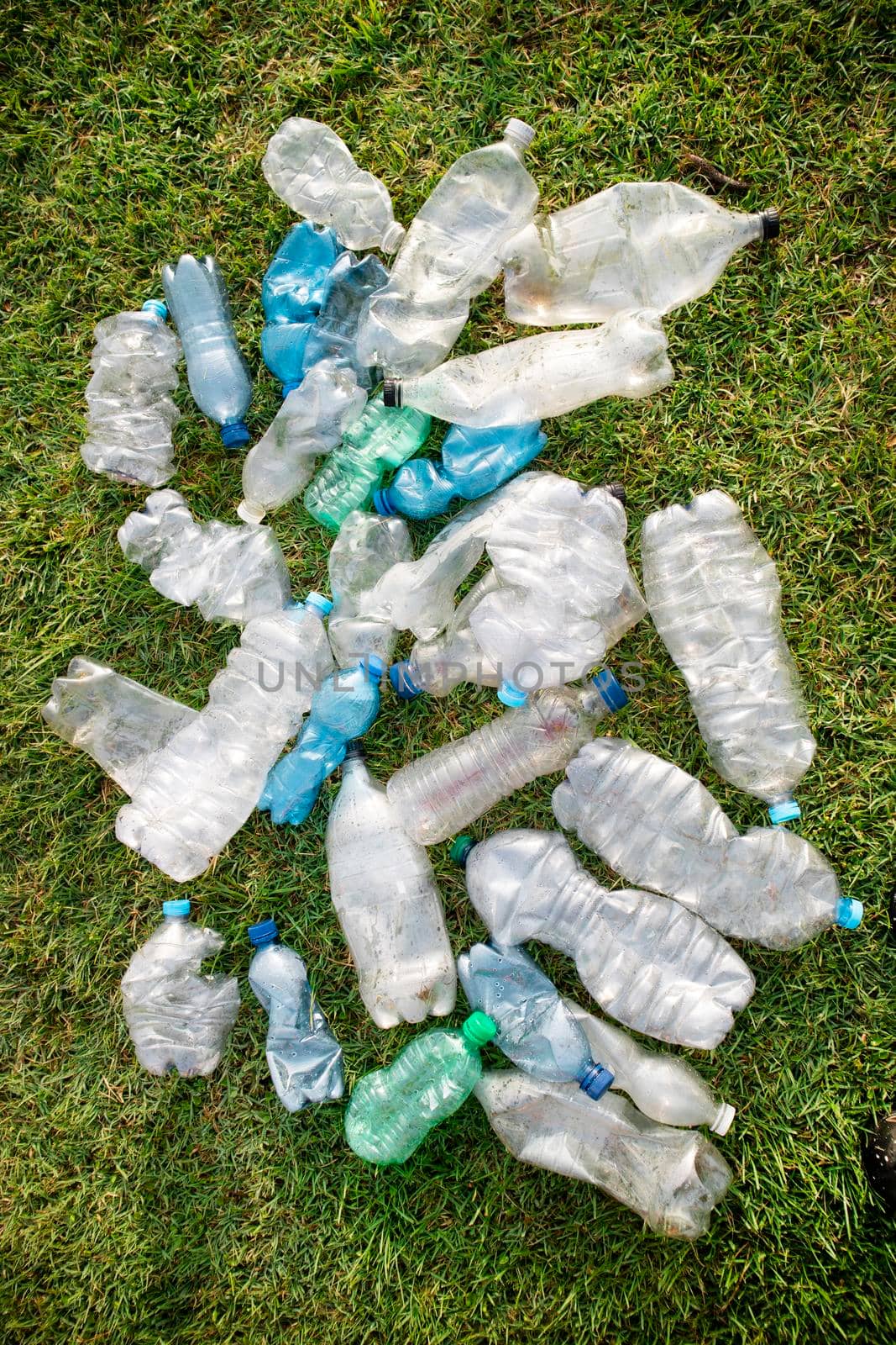 Sign of incivility used plastic bottles abandoned in a meadow 