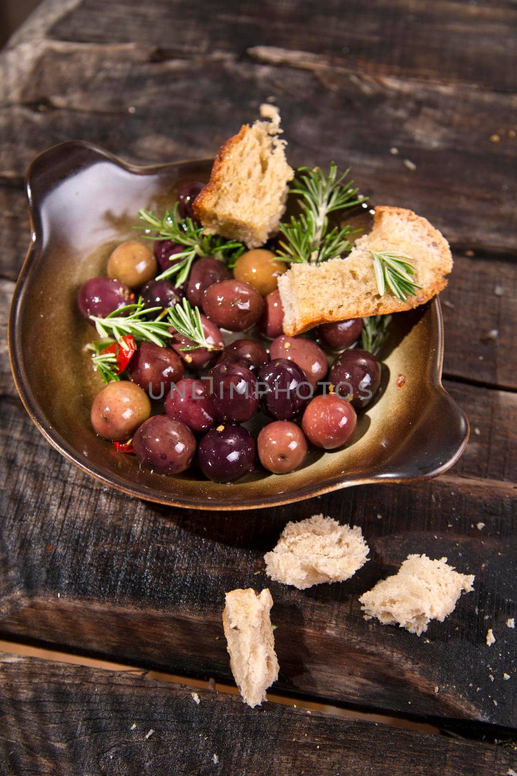 Snack of homemade bread and black olives in brine