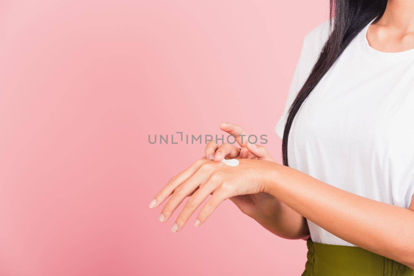 woman applying lotion cosmetic moisturizer cream on her behind the palm skin back hand by Sorapop