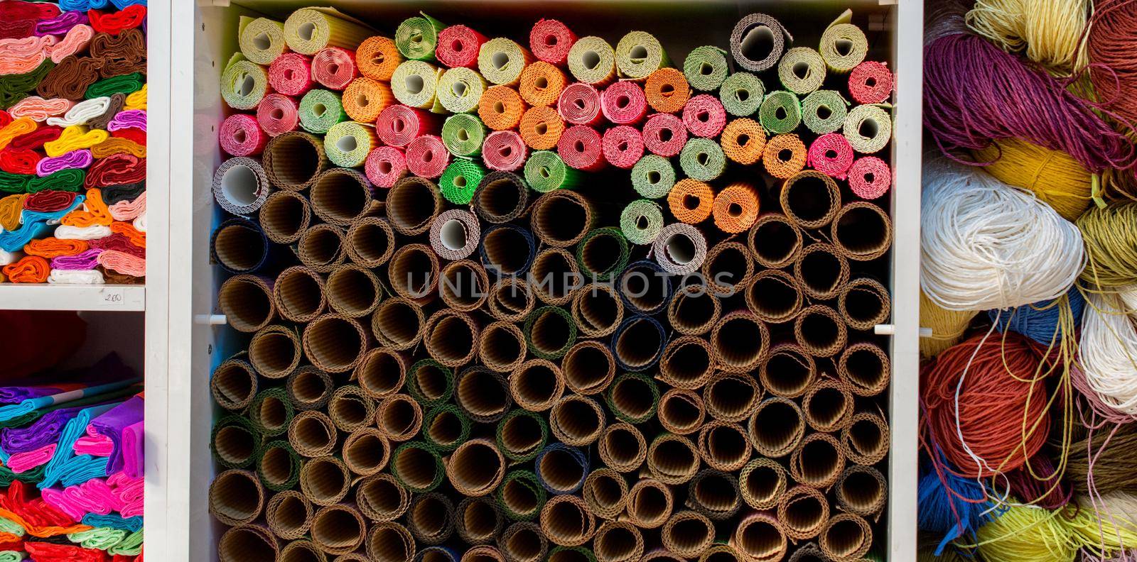 Dozens of colorful paper rolls in display by berkay