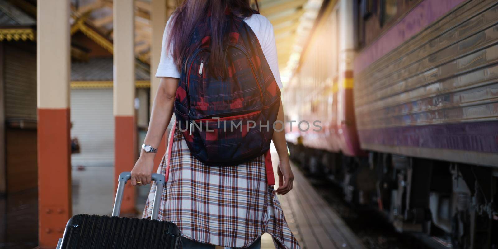 Alone traveler tourist walking with backpack and luggage at train station. work and travel lifestyle concept