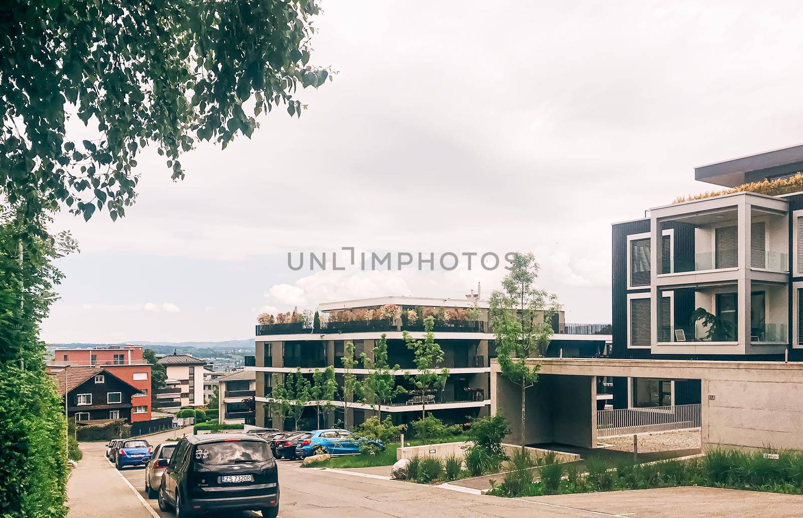 Wollerau, canton of Schwyz, Switzerland circa June 2021: Modern apartment buildings and street, Swiss architecture and real estate