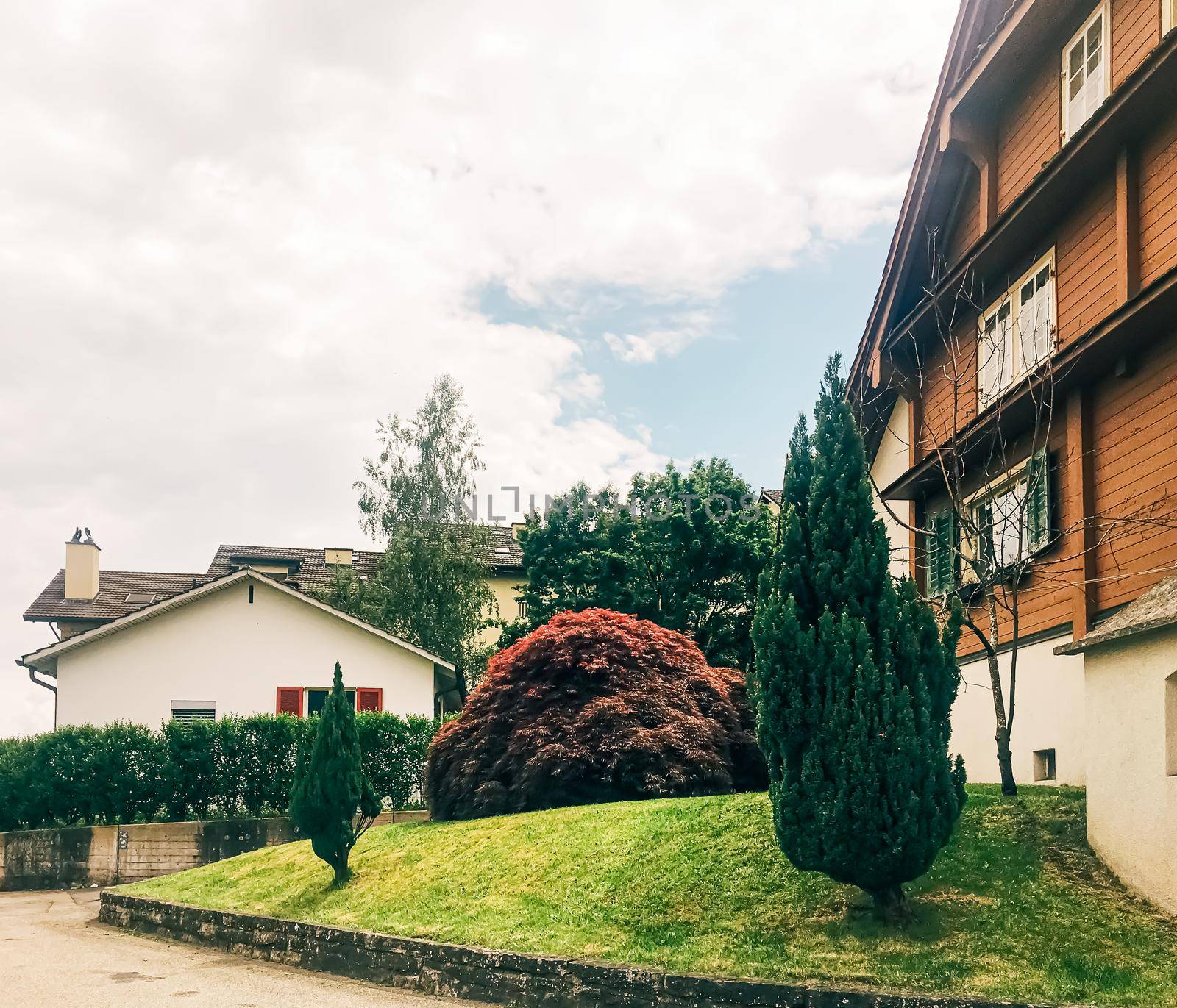 Wollerau, canton of Schwyz, Switzerland circa June 2021: Apartment building and house on street, Swiss architecture and real estate