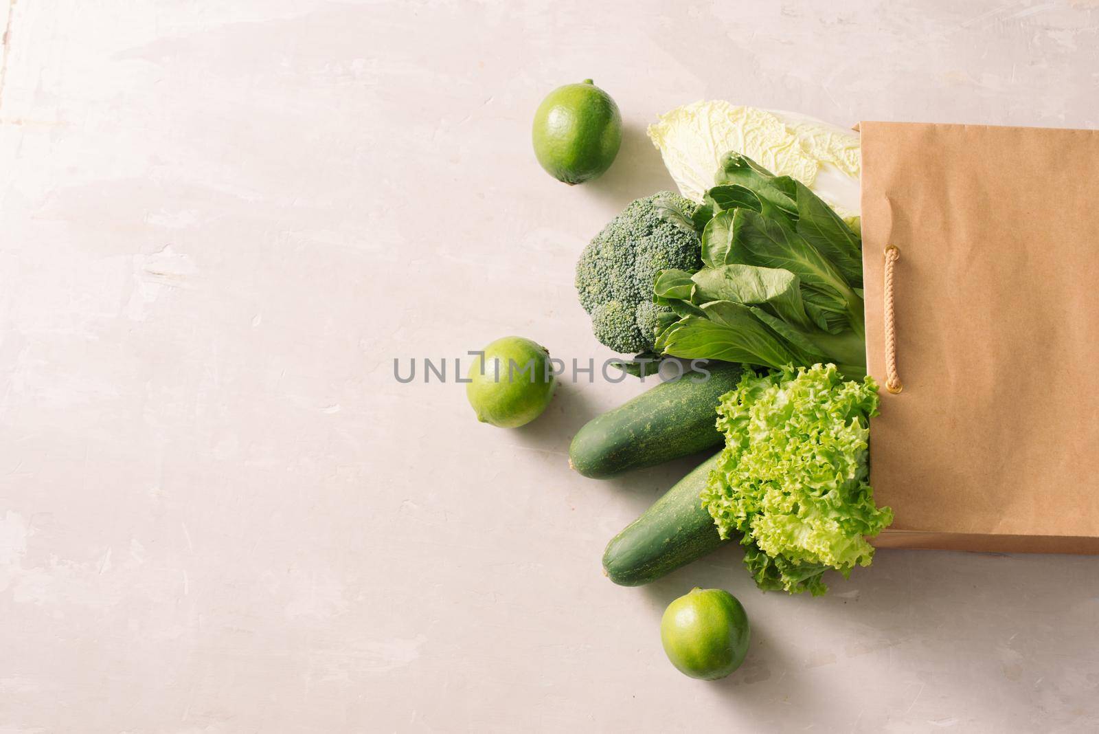 Fresh and juicy raw vegetables in a paper shopping back. White background. by makidotvn