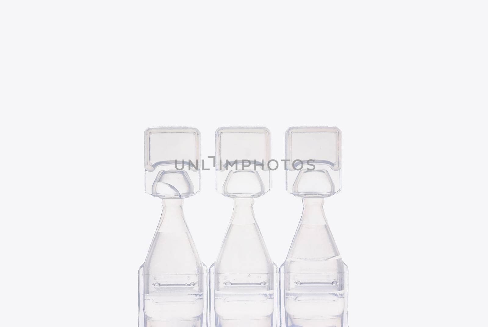 Eye drop bottles on white background. Blank white plastic containers for fluid. Pharmaceutical packaging product.