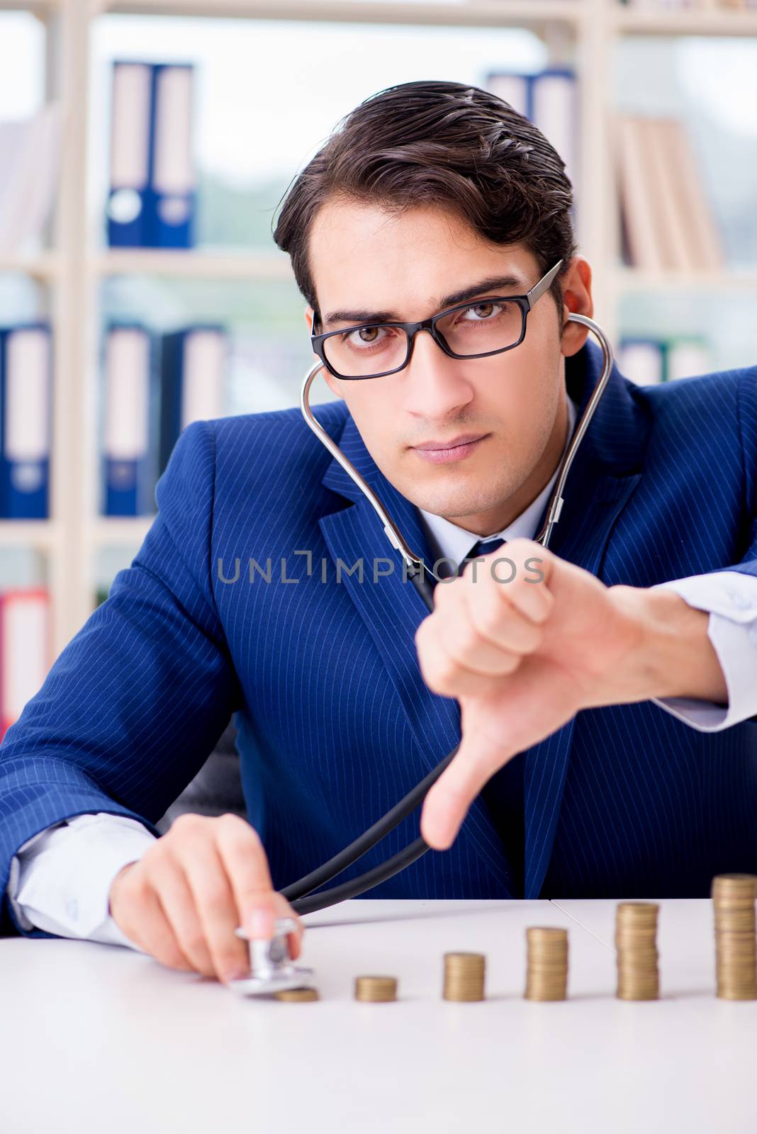 Businessman with stacks of coins in the office