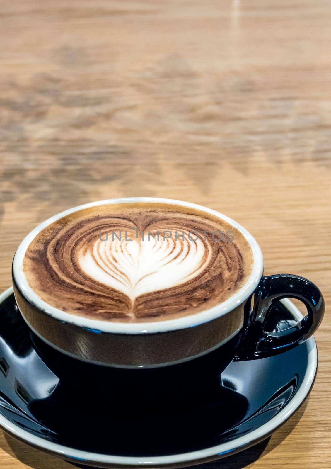 Coffee in black cup on wooden table