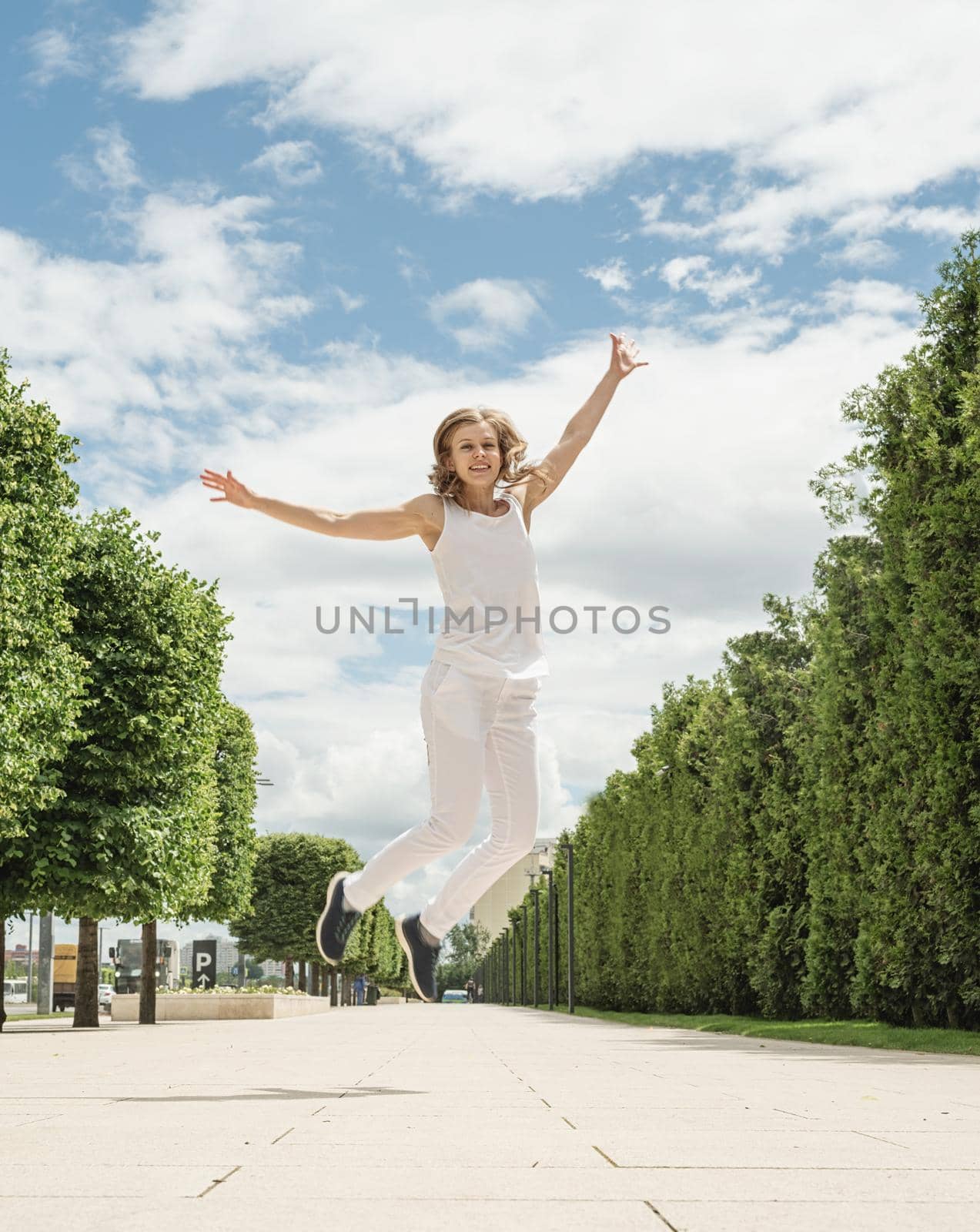 Happy young woman in white t-shirt jumping and screaming in the park. mock up design