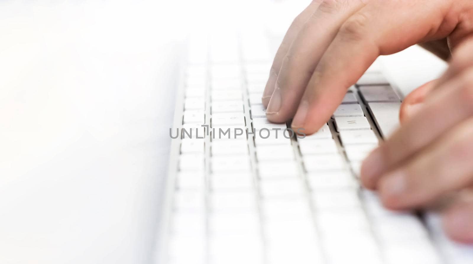 a male hand over the white keyboard of a computer before typing. Work and employment. Technology