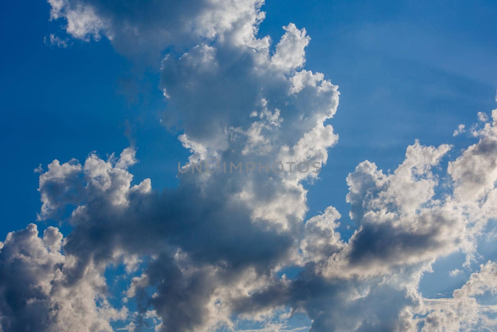 white c cumulus clouds on blue sky background telephoto view