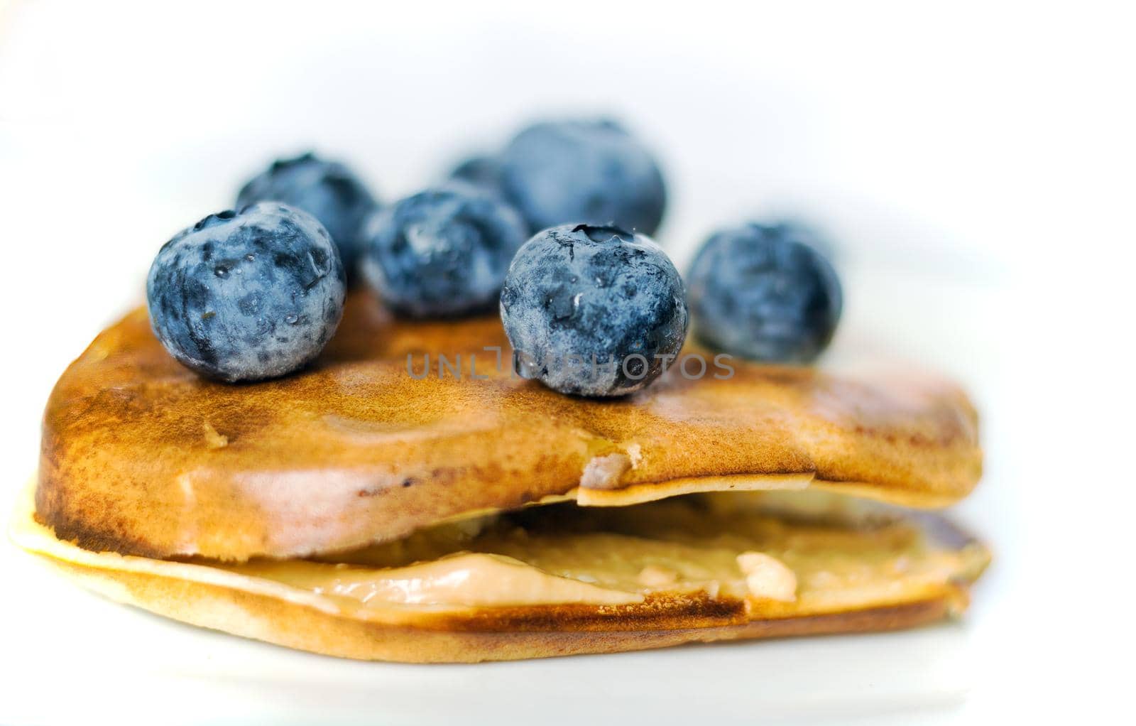 Healthy food concept displaying macro close up shot of pan cake with blueberries fruit and banana isolated on white background