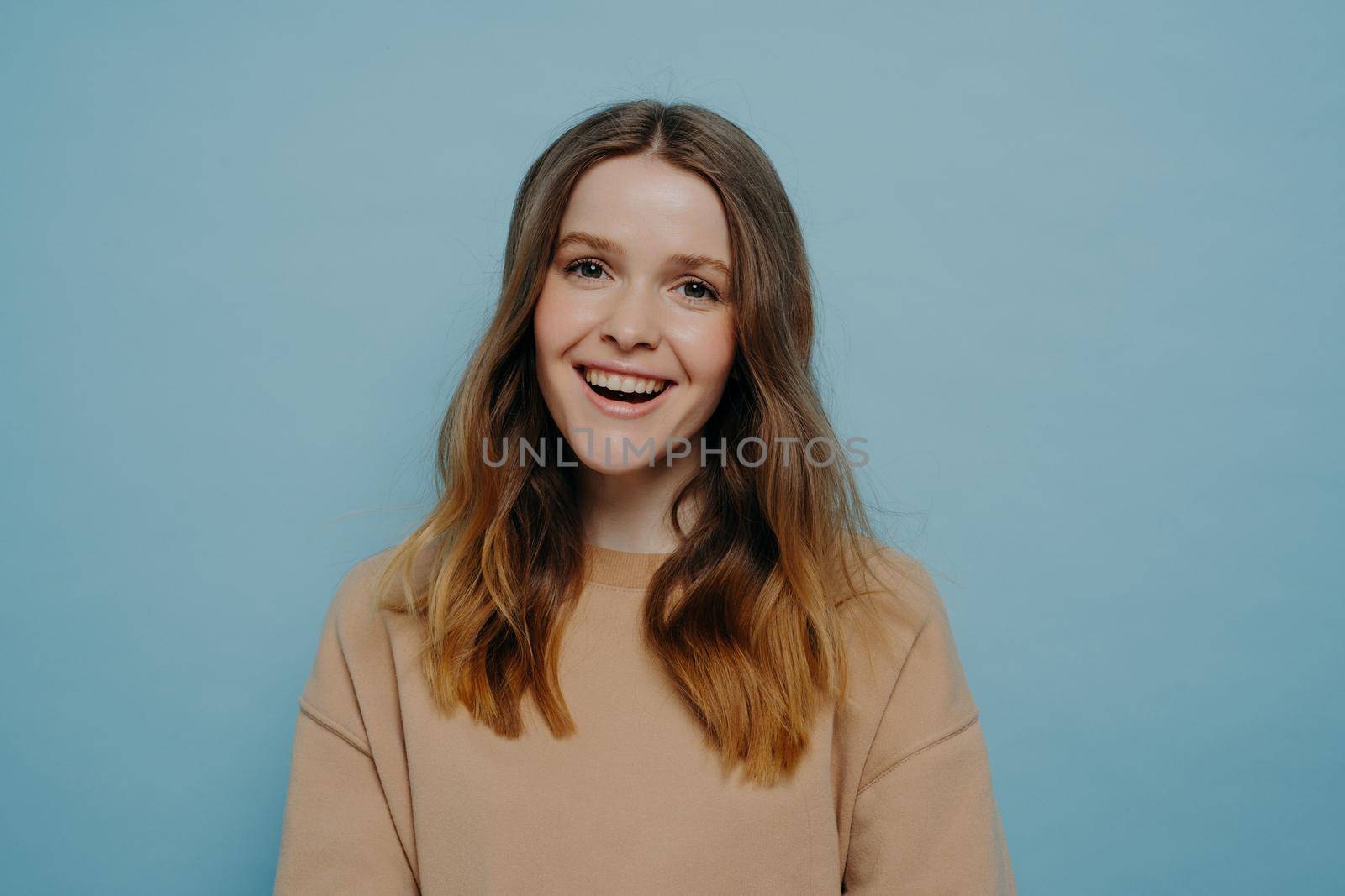 Happy teenage girl looking at camera with positive expression by vkstock