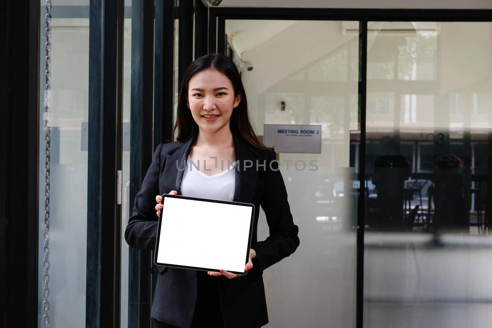 Business woman holding digital tablet with white screen at office.