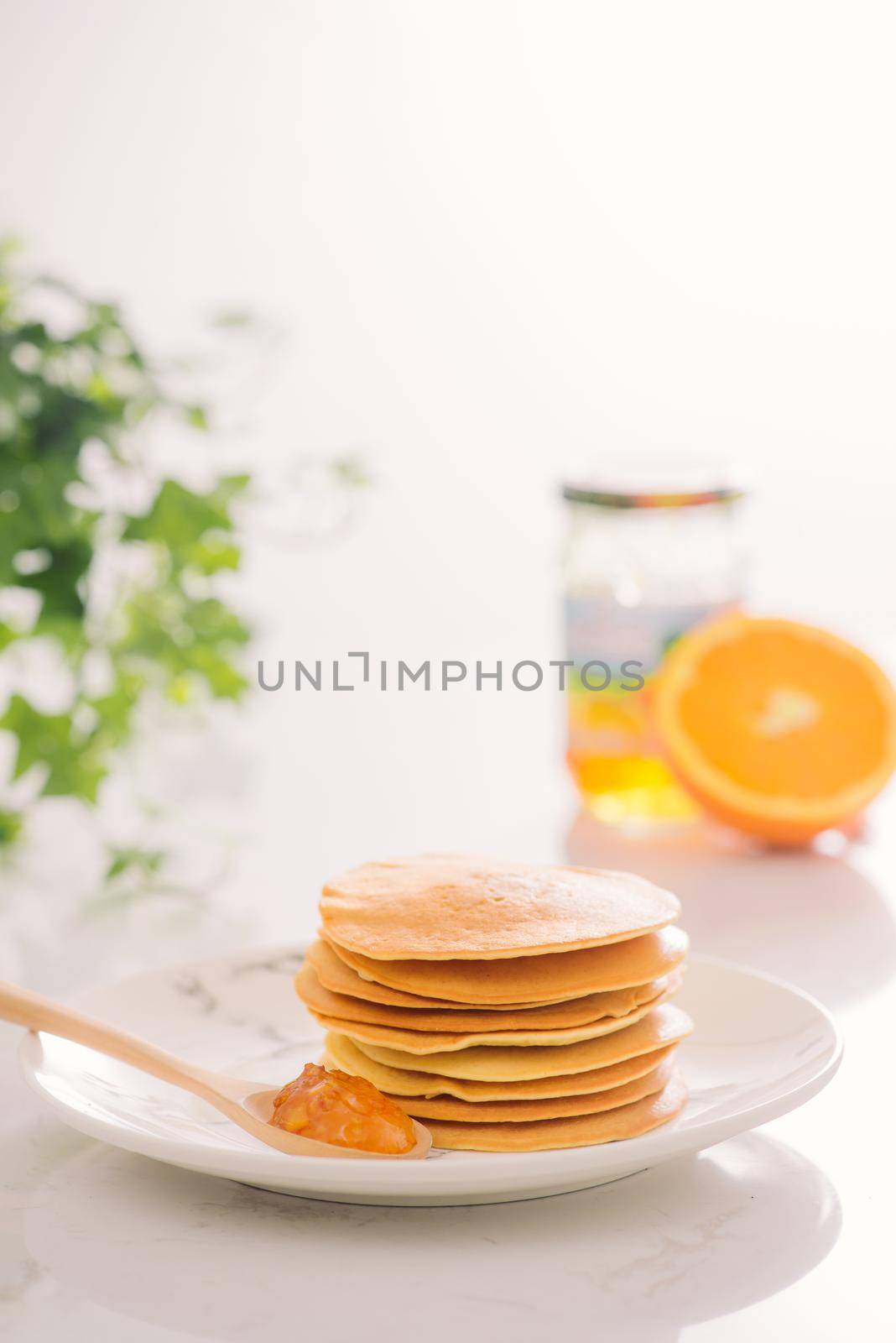 Stack of delicious pancakes on plate isolated on white