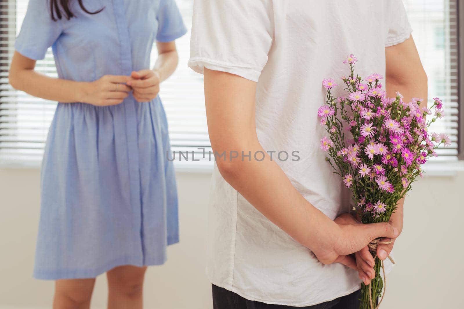 Couple in love. Romantic man giving flowers to his girlfriend