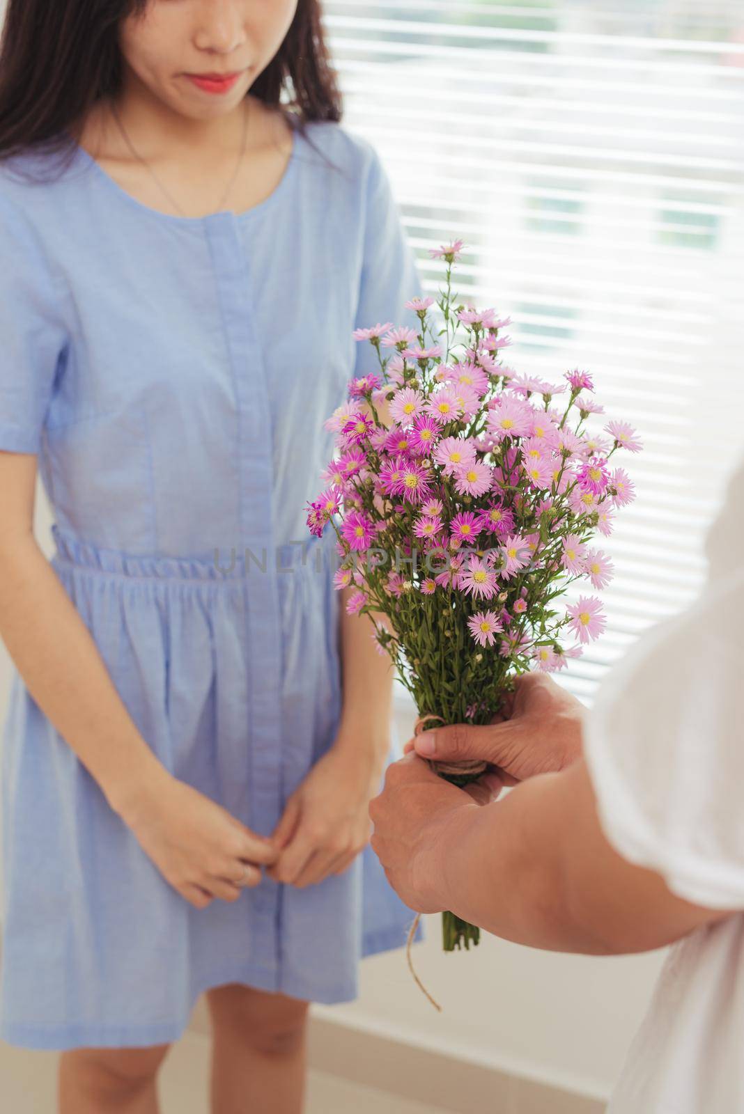 Couple in love. Romantic man giving flowers to his girlfriend by makidotvn