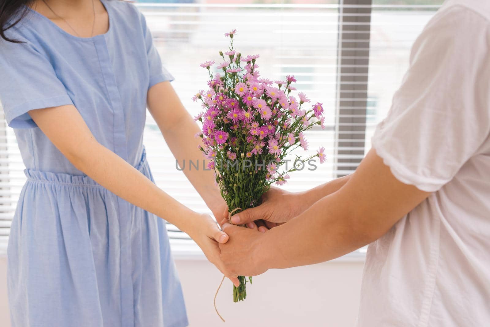 Couple in love. Romantic man giving flowers to his girlfriend