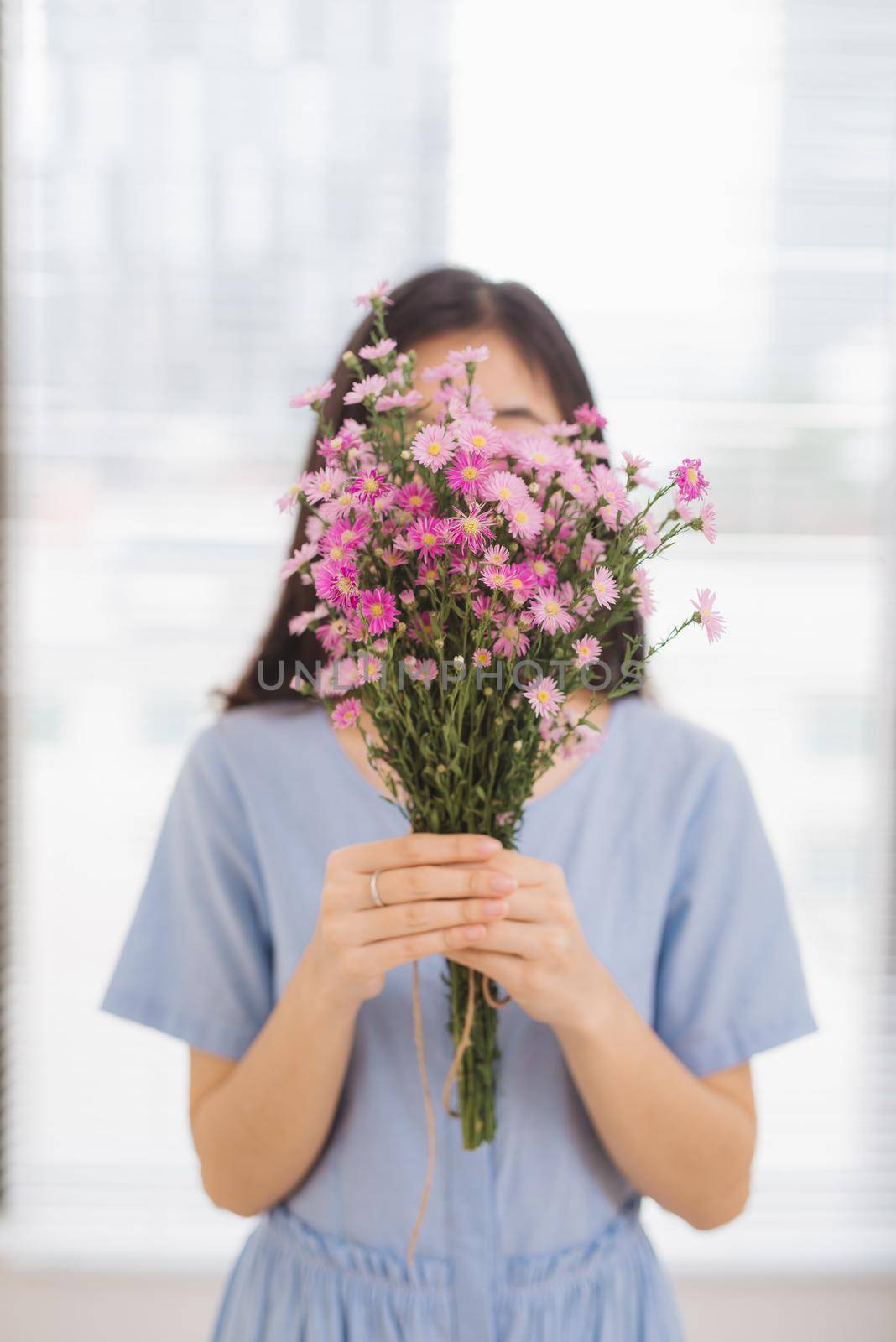 Studio shot of happiness woman receiving pretty flowers by makidotvn