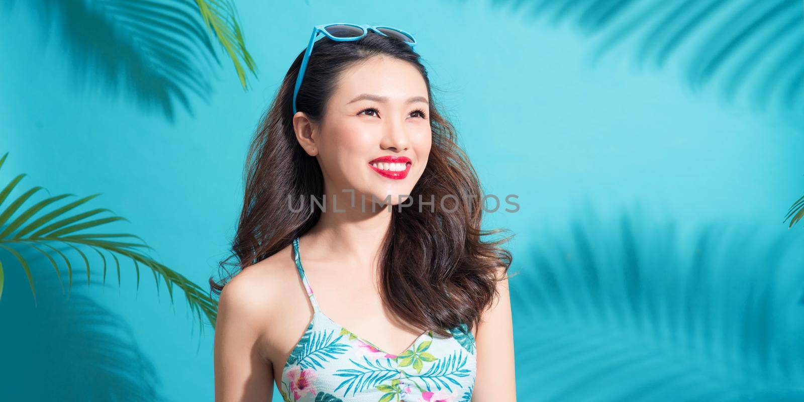 Banner size. Summer fashion girl standing and smiling over vibrant blue background