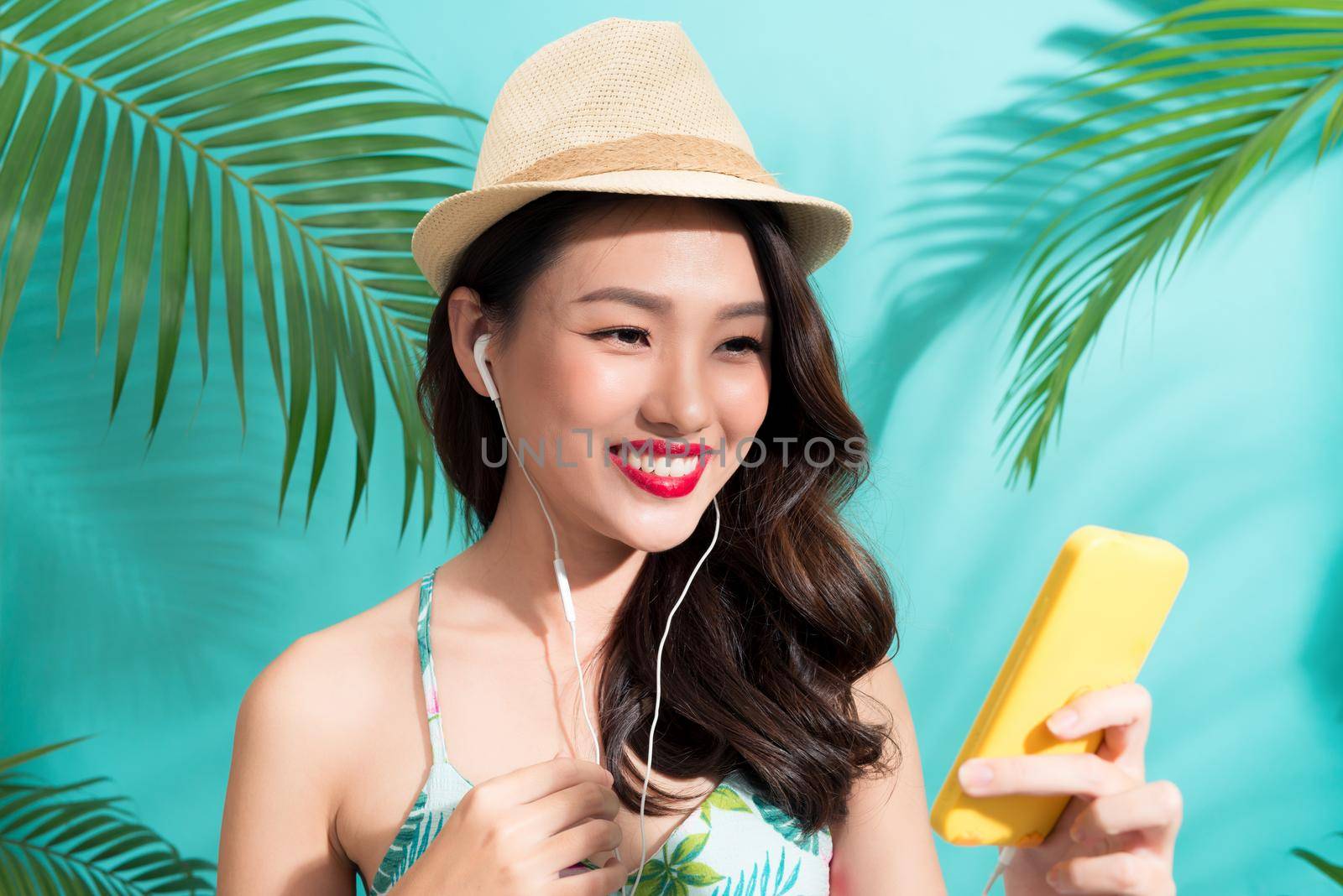 Summer fashion girl standing and smiling over vibrant blue background
