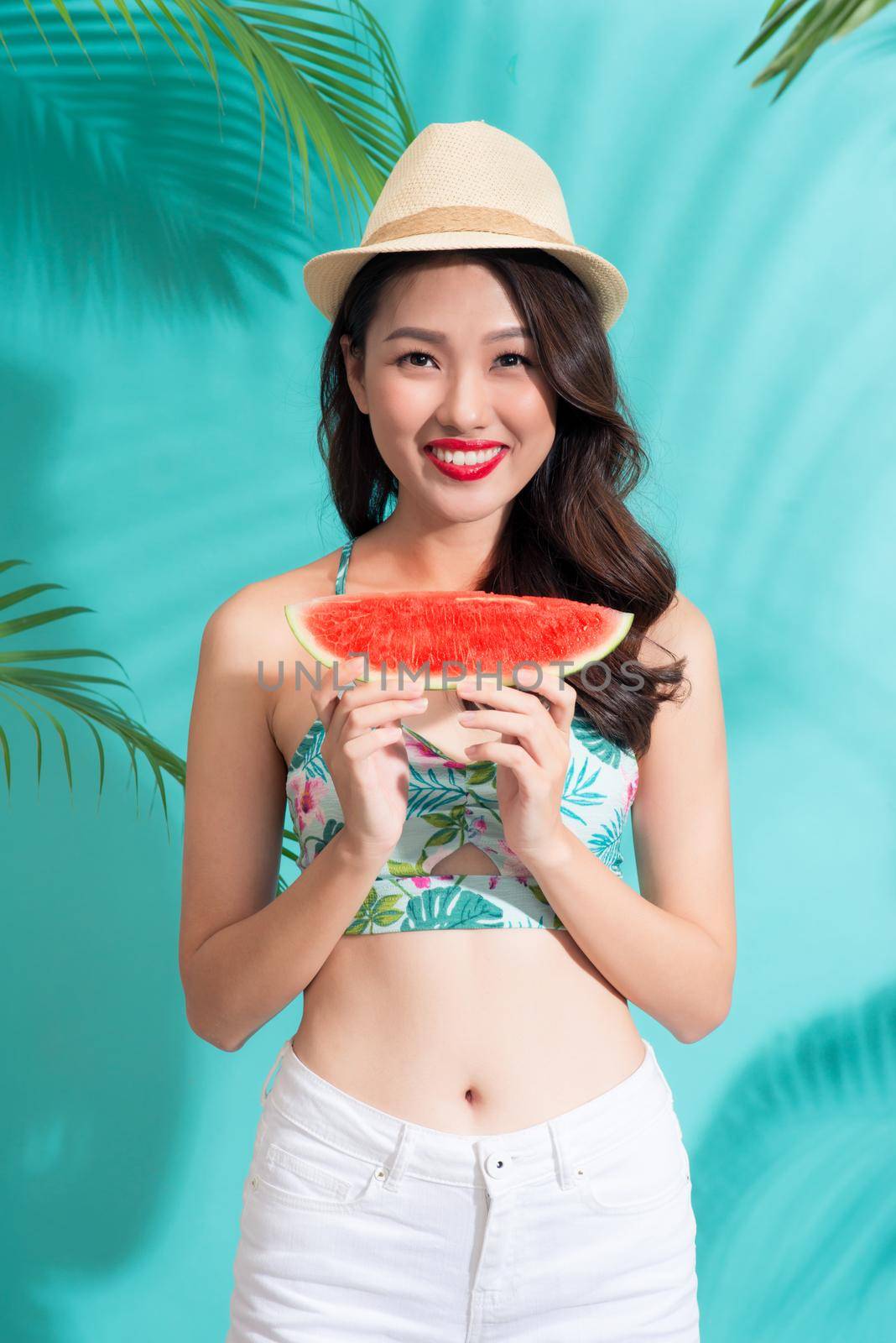 Beautiful young asian woman holding slice of watermelon and smiling by makidotvn