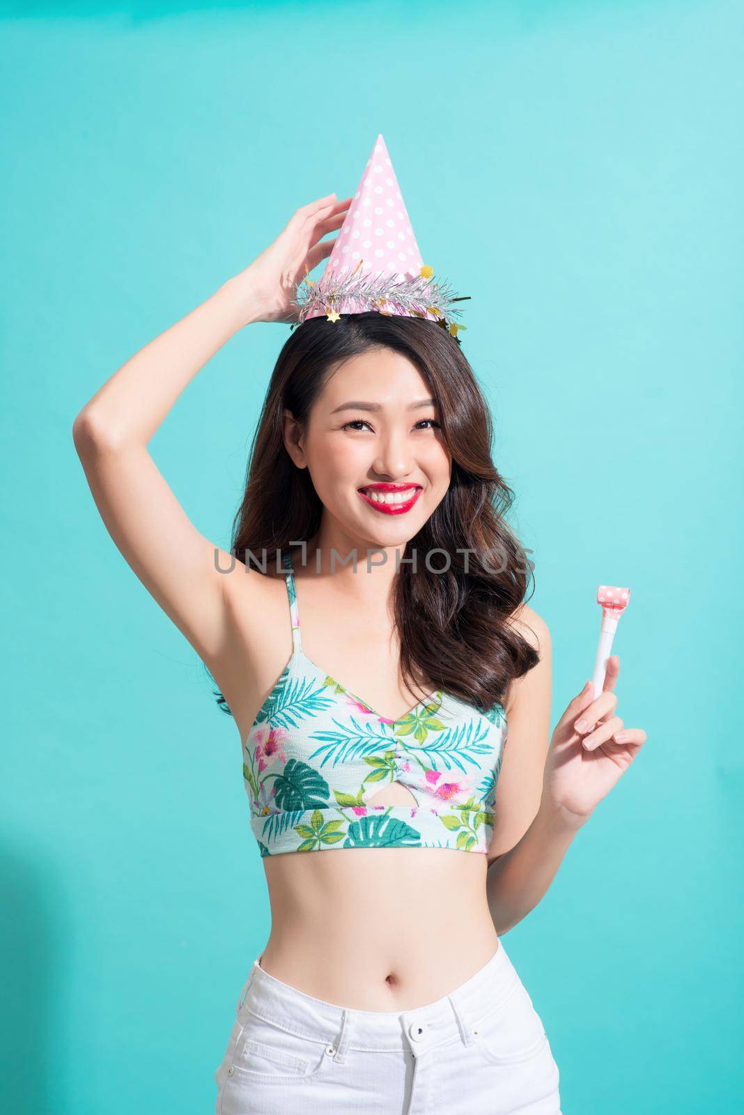 Fashion pretty woman holding candy over colorful blue background