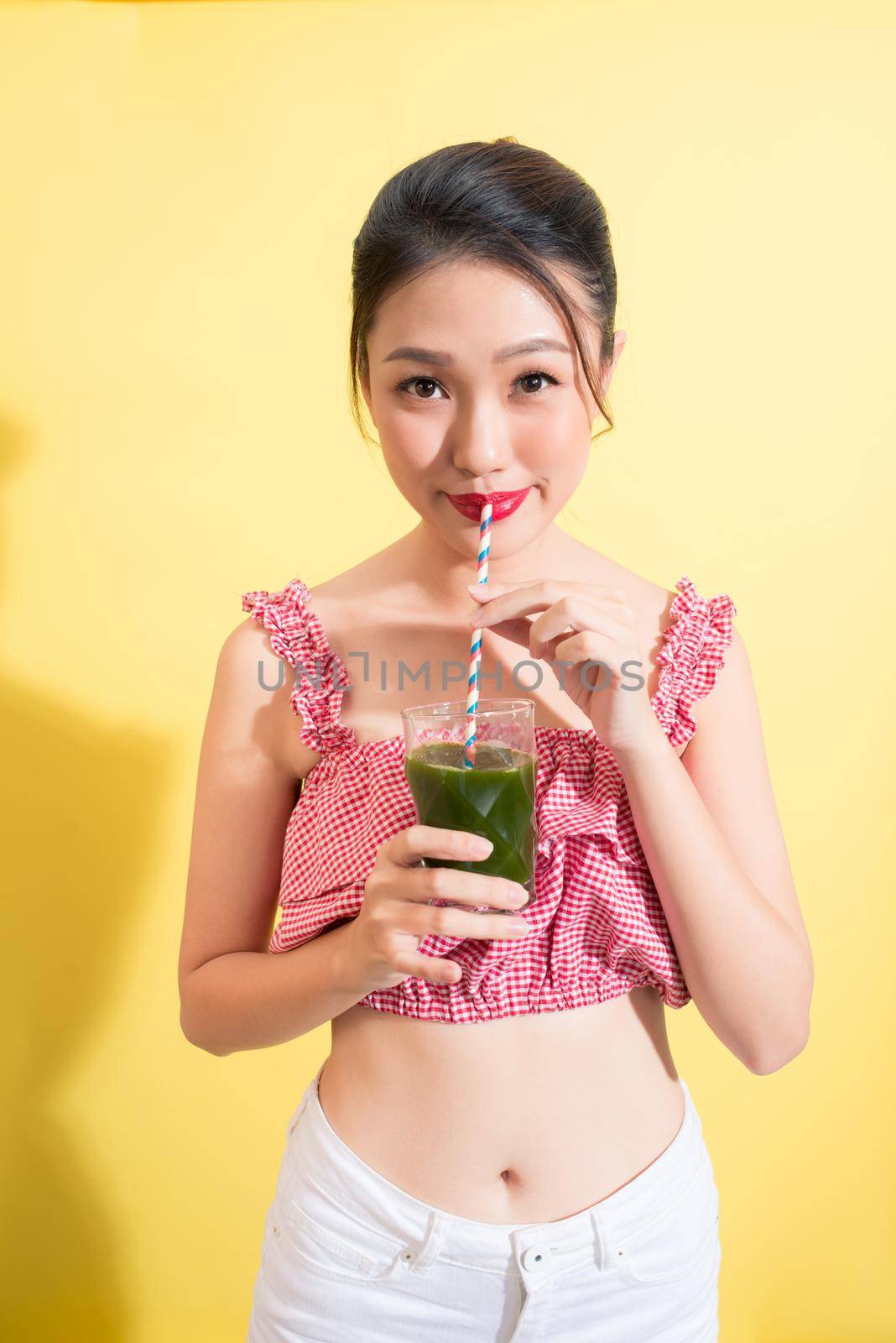 Asian beautiful woman summer outfit posing with glass of fresh detox.