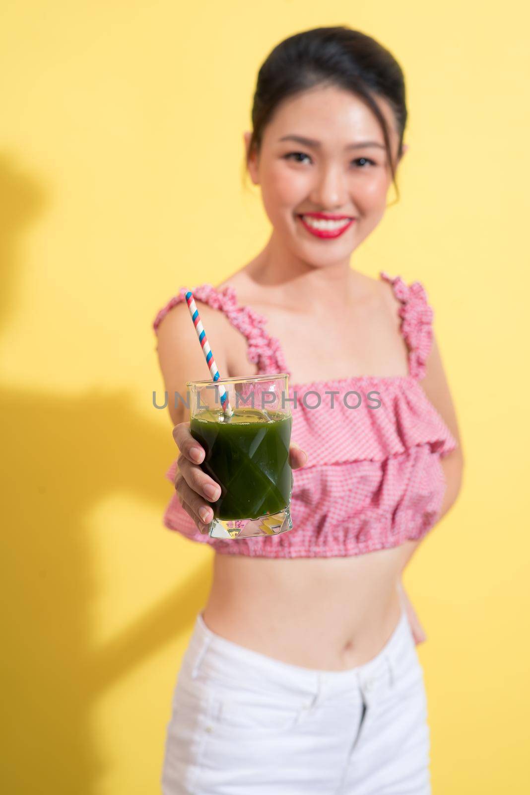 Fashion portrait of young fashionable woman in summer outfit posing with fresh detox smoothie cocktail by makidotvn