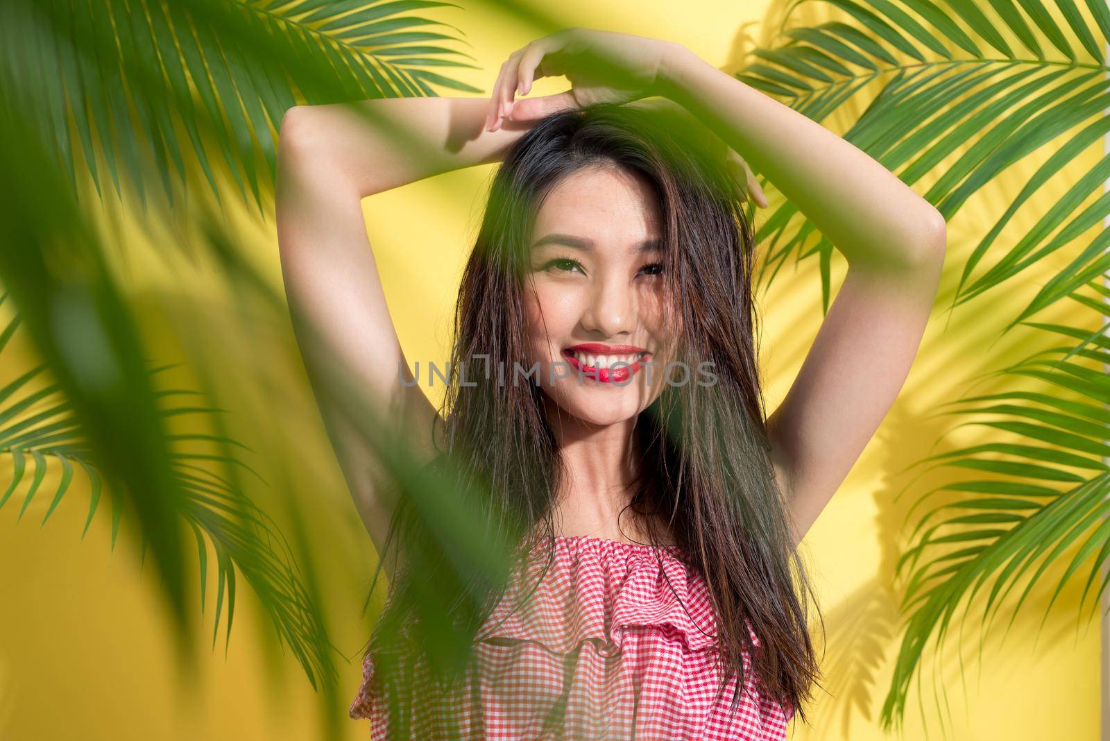 Fashion pretty asian woman posing and smiling over bright summer background