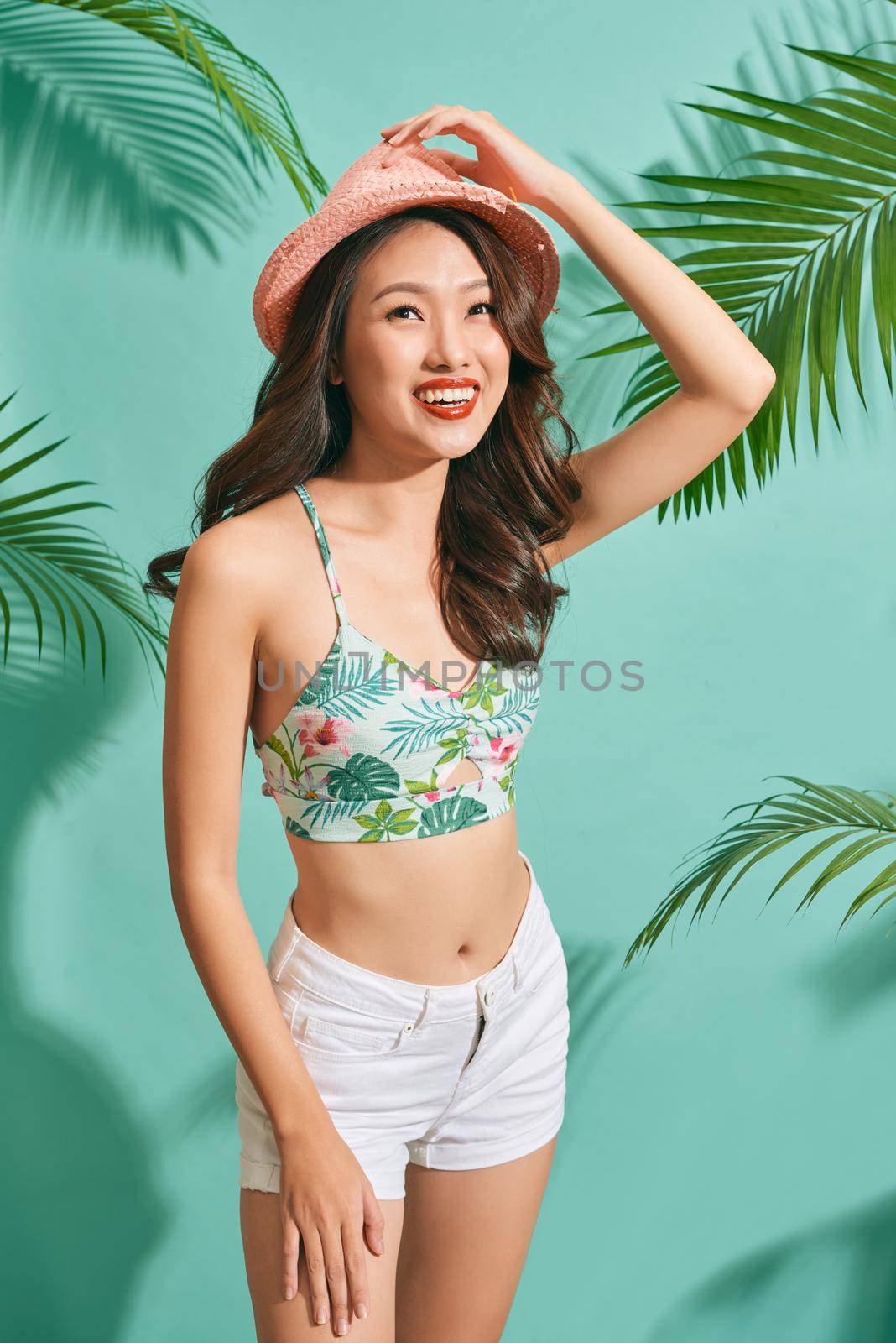 Happy woman wearing a summer clothes having fun isolated on bright blue background 