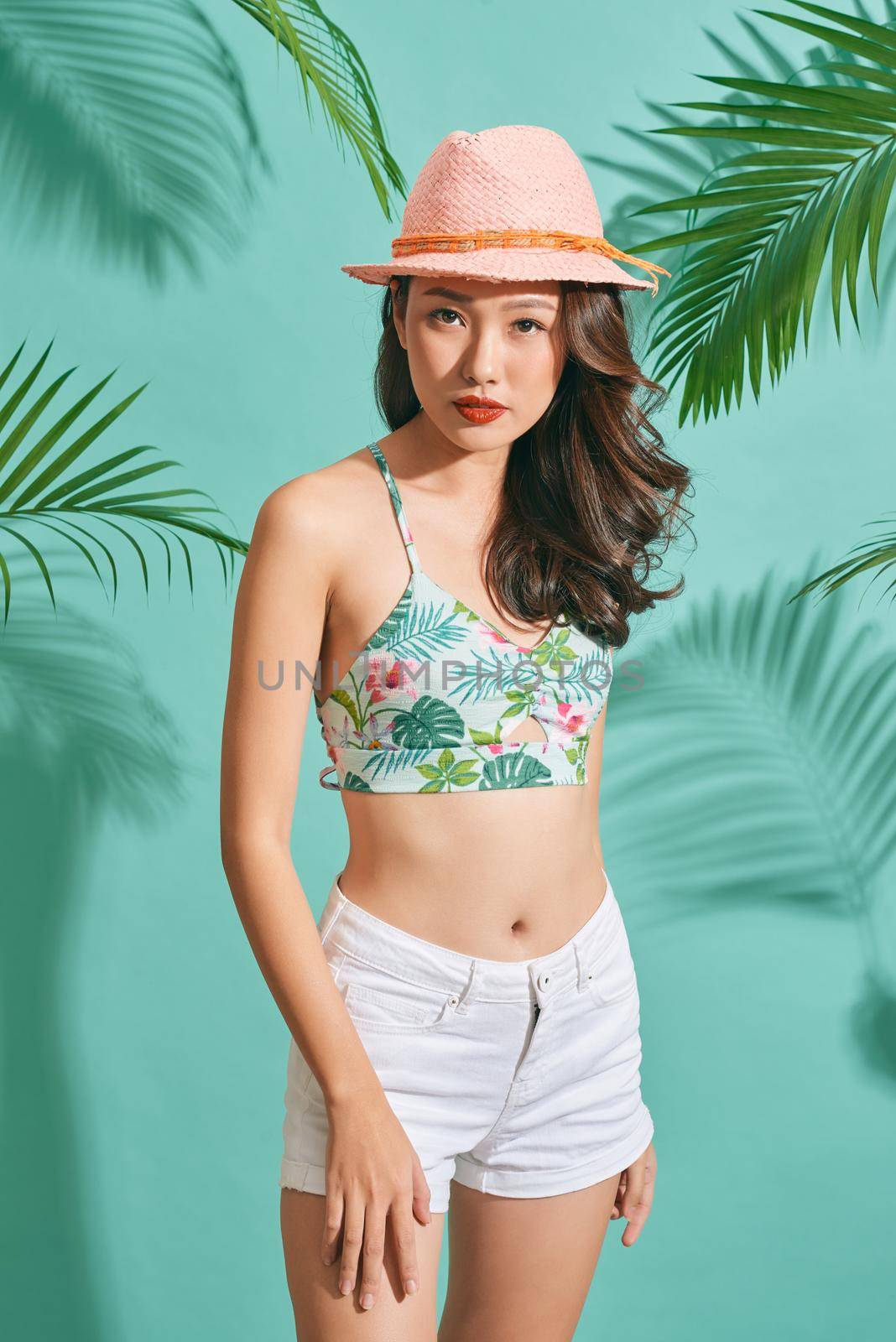 Happy woman wearing a summer clothes having fun isolated on bright blue background 