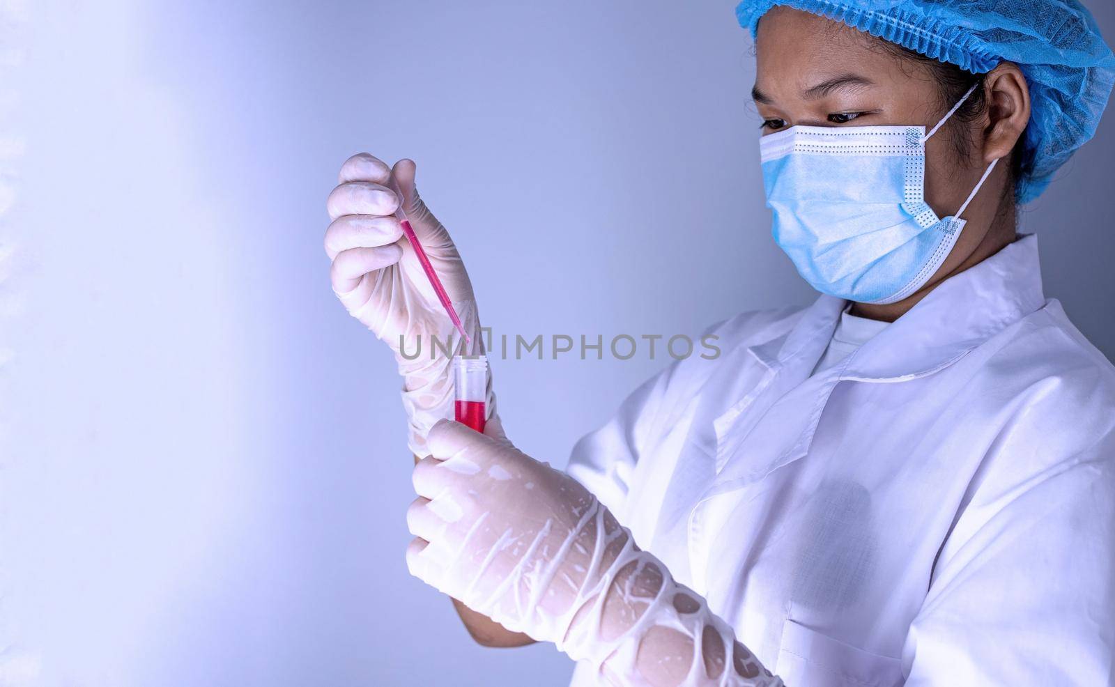 Woman chemist holds flask with red liquid in her hands in chemical laboratory.  Products quality control concept. by Unimages2527