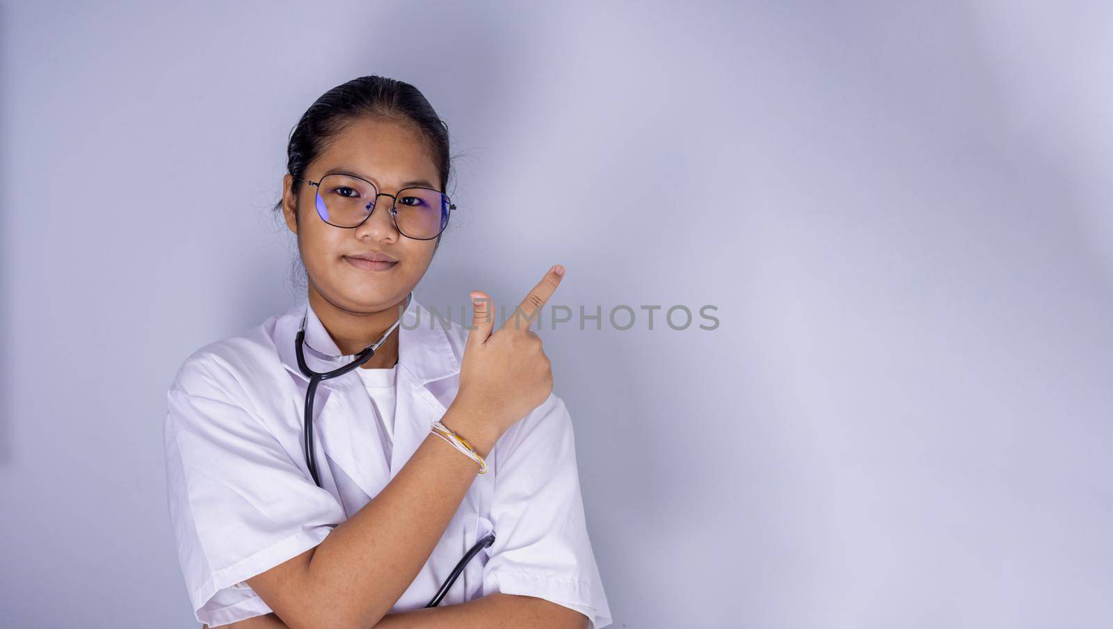 Portrait of a female doctor wearing glasses Standing with arms crossed on a white background.