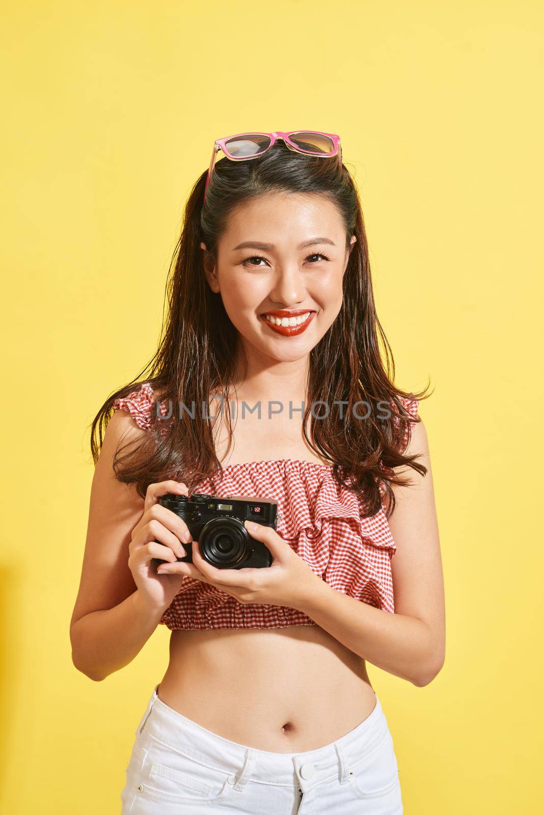 A young Asian woman photographer holding film camera
