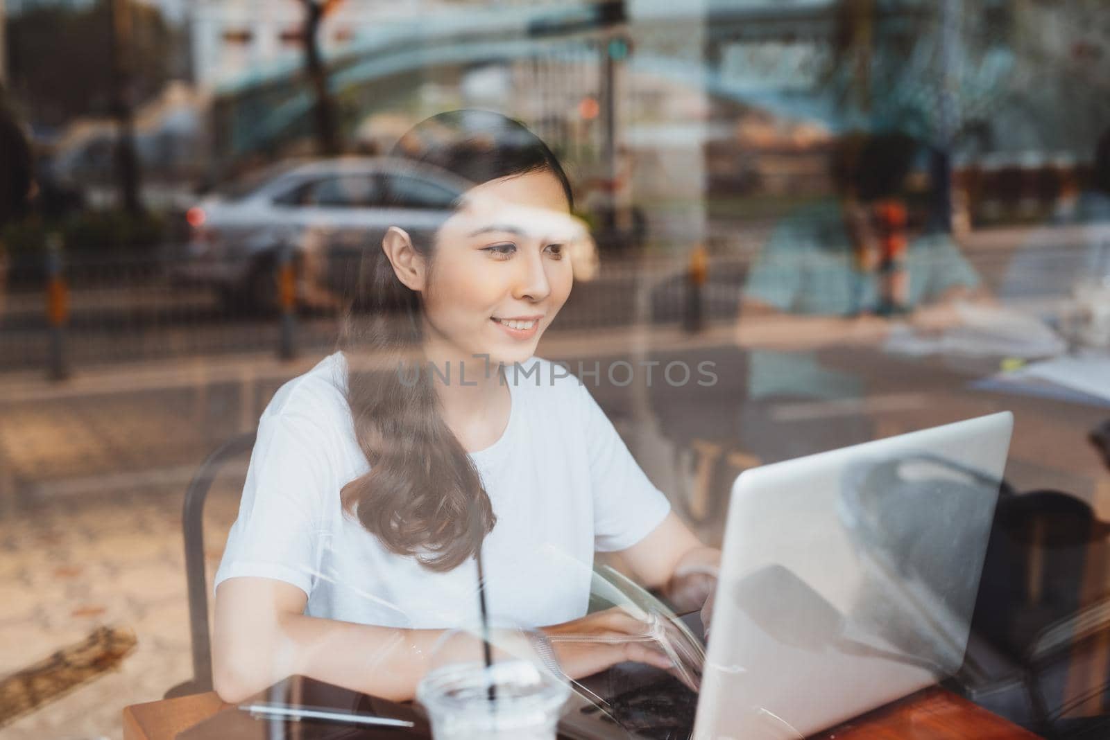 Portrait of happy young business woman with mug in hands drinking coffee in the morning at cafe