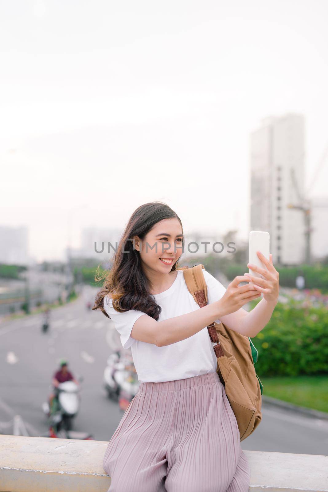 Young beautiful with long hairstyle woman taking selfie outdoor.
