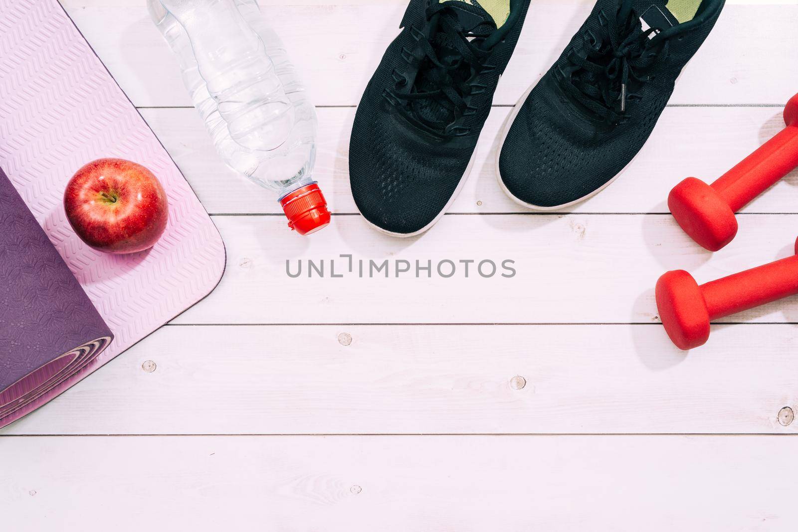 Bright sport shoes with dumbbell and yoga mat