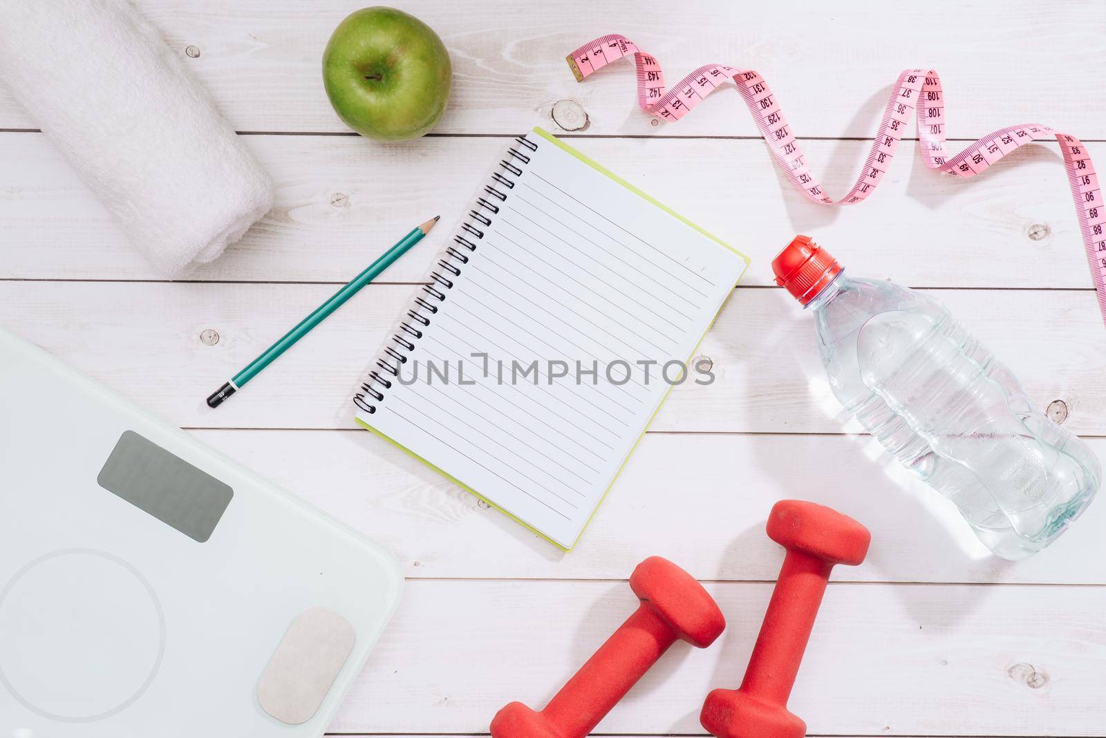 fitness concept with dumbbells and red apple - sport and leisure