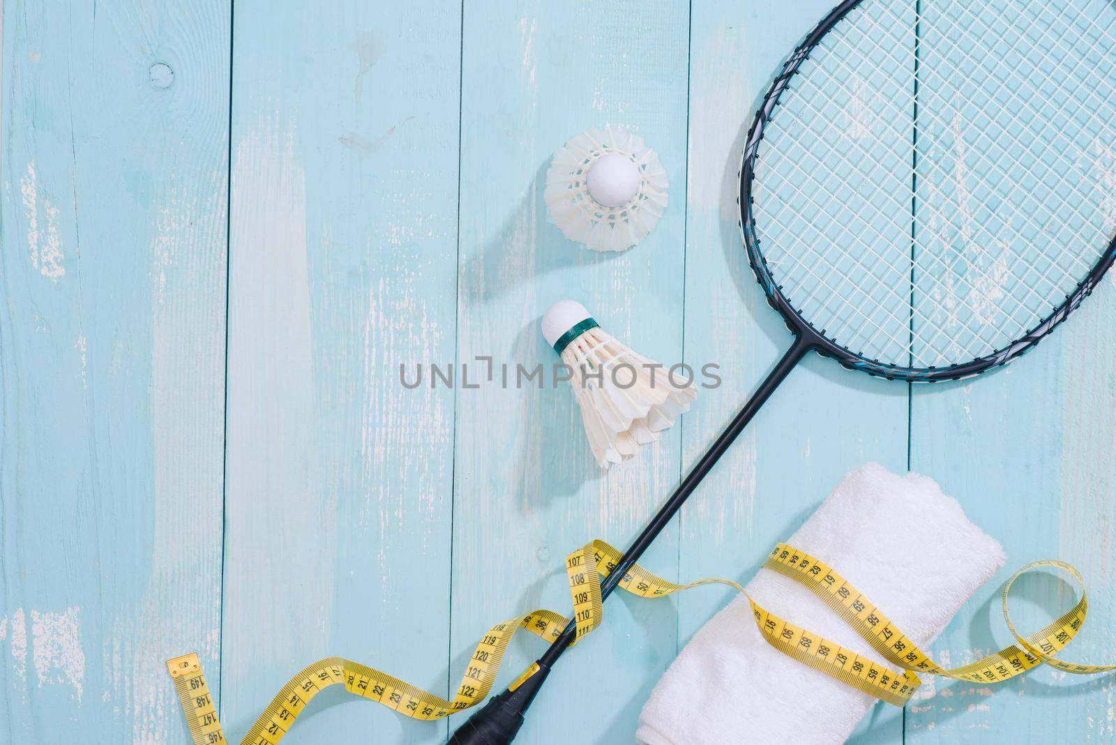 Top view of sport equipments, clock, tape measure, shoes, water bottle, towel, badminton racket and shuttlecock, Healthy lifestyle and fitness concept