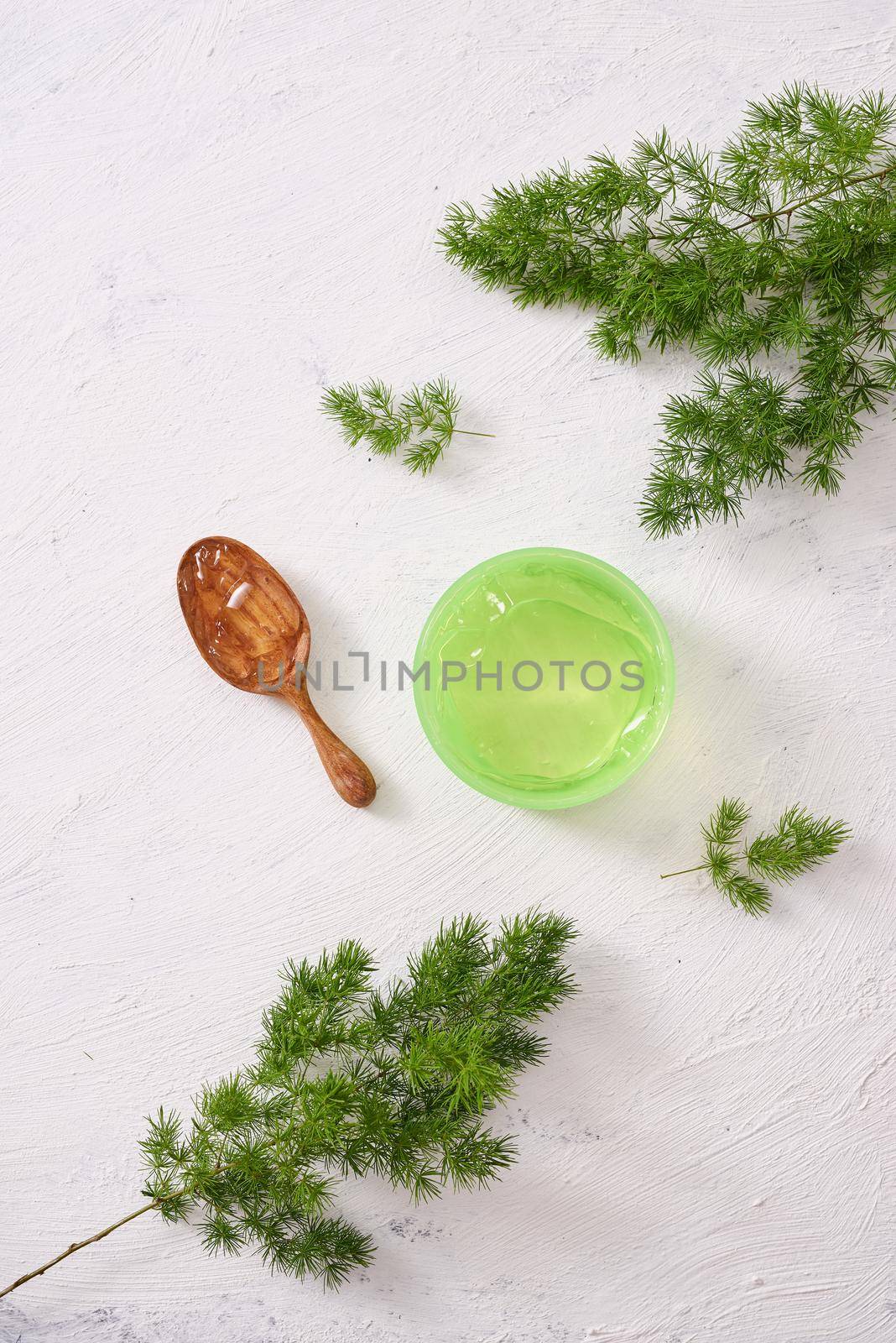 cosmetic creams with leaves on white wooden table background