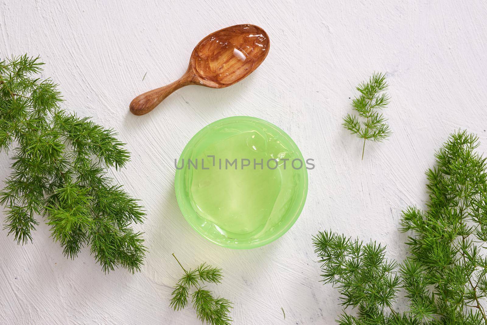 cosmetic creams with leaves on white wooden table background