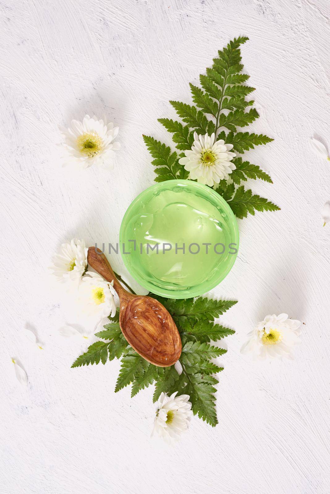 spa setting with cosmetic gel, leaves on white table background by makidotvn