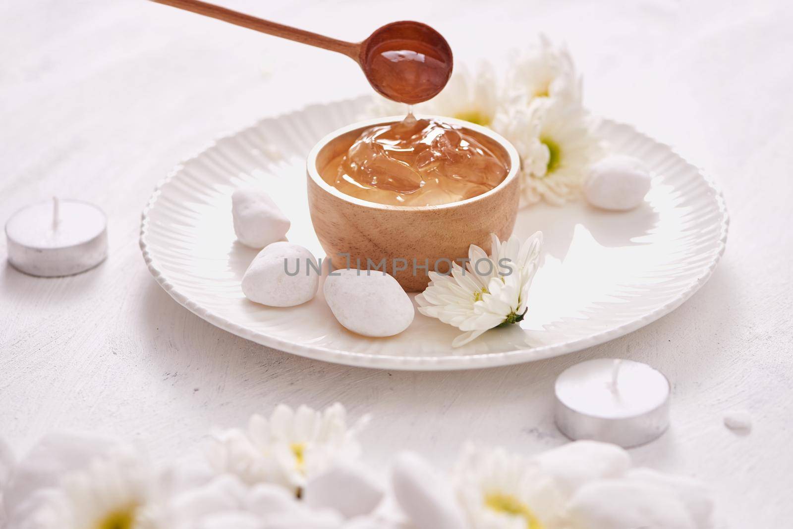 Aloe vera gel on a bowl, with chrysanthemum and candle in stone table by makidotvn