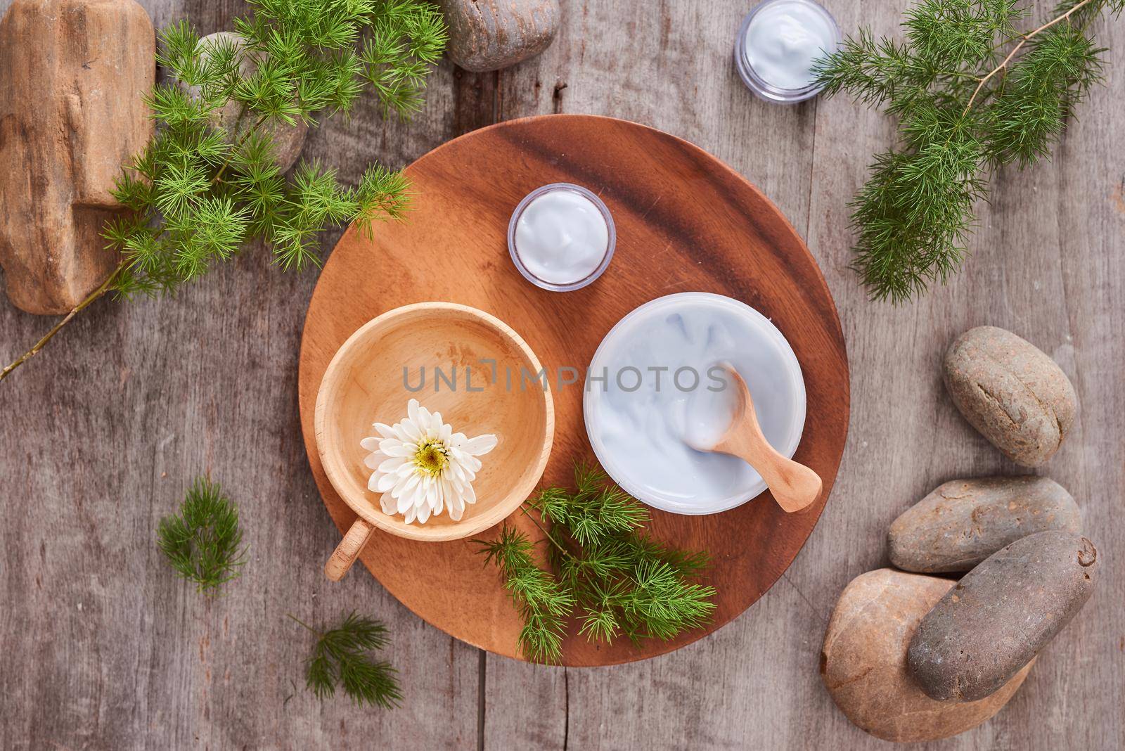 cosmetic cream and fresh  leaves on wooden table background